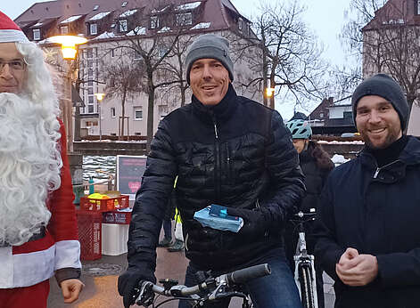 Nikolaus mit zwei Männern und Fahrrad mit Licht