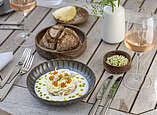 Eingedeckter Tisch mit vegetarischer Speise, Brot und Wein.