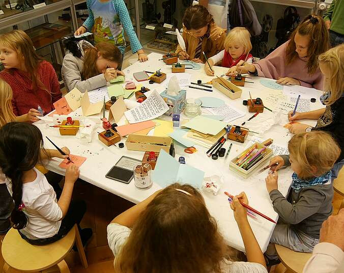 Kinder bei einer Bastelstation