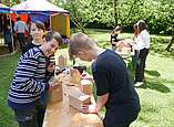 Mit Holzbohrern und Schleifpapier gestalten die ukrainischen Kinder im Museumsgarten ihre Insektenhäuser.