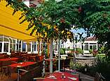 Terrasse mit Tischen und Stühlen im Rosengarten der Krone Schnetzenhausen