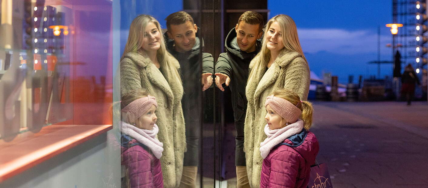 Familie vor einem Schaufenster