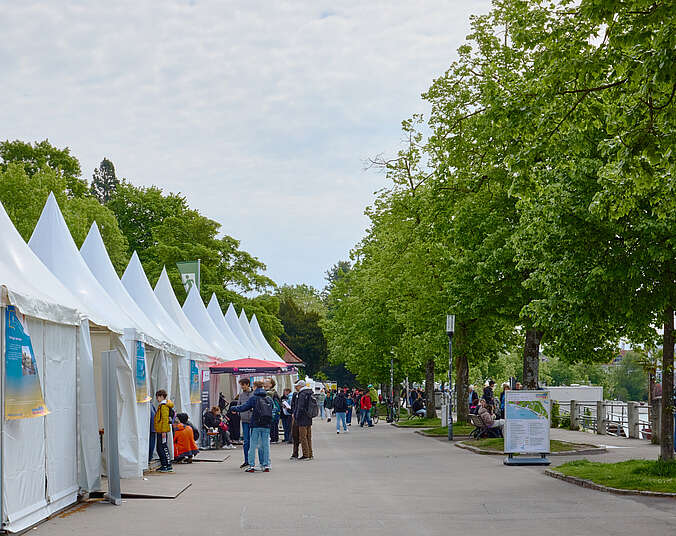 Pavillons und Menschen an der Uferpromenade