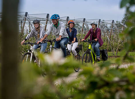 Ein Mann und drei Frauen fahren Fahrrad.