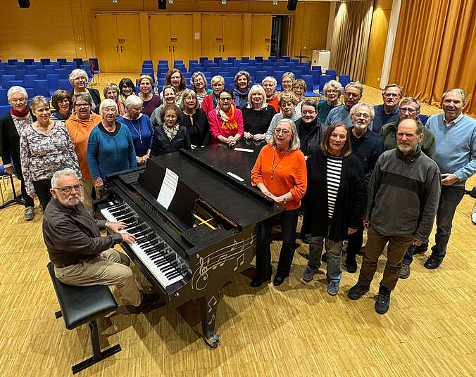 Menschen stehen rund um ein Klavier
