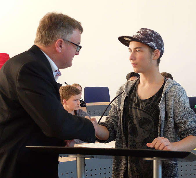 Oberbürgermeister schüttelt einem Jugendlichen die Hand