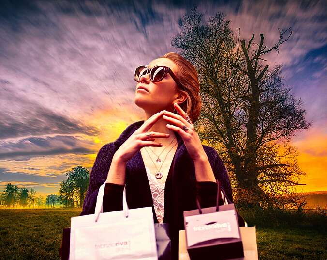 Frau mit Sonnenbrille und Einkaufstüten.