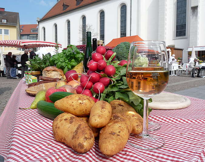 Tisch mit Kartoffeln, Radieschen und Weinglas