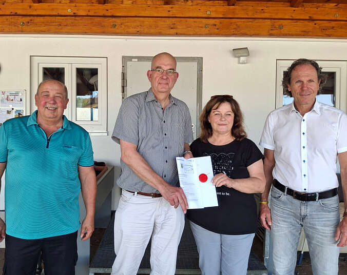 Gruppe von drei Männer und einer Frau mit Kaufurkunde