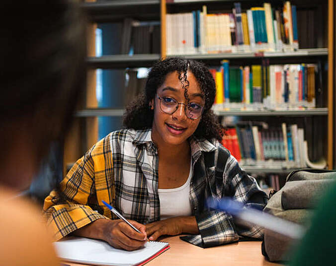 Mädchen am Schreibtisch hört zu und schreibt