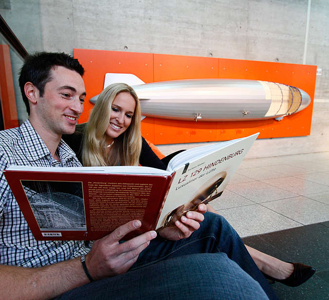 Mann und Frau schauen Buch im Zeppelin Museum an