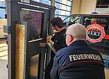 Claudio Bercher hält und lenkt das Halligon Tool in den Spalt der Türe während Ralf Sesterhenn mit gezielten Schlägen das Werkzeug reintreibt.