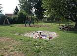 Spielplatz mit Sandkasten und Schaukel