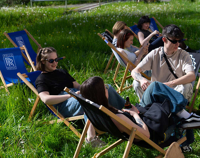 Menschen sitzen auf einer Wiese