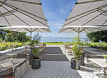 Terrasse mit Tischen und Pflanzen mit Blick auf den Bodensee.