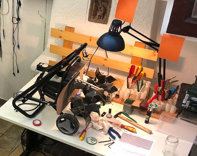 Defektes Gerät steht auf einem Tisch mit viel Werkzeug dabei
