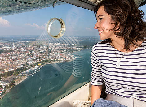 Frau schaut aus Zeppelin auf den Bodensee