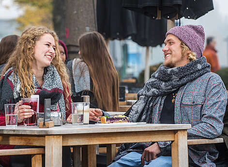 Paar sitzt im Herbst im Straßencafè