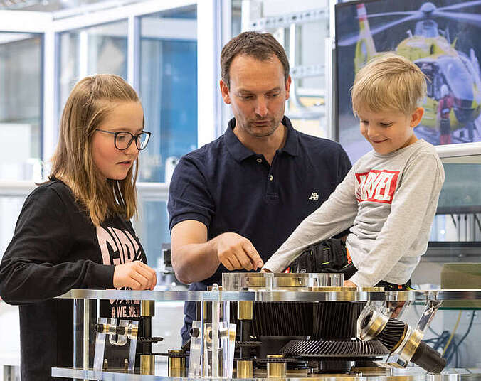 2 Kinder und Mann beim Experimentieren
