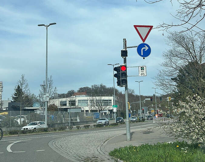 Straßenkreuzung mit Ampelmast und Schildern