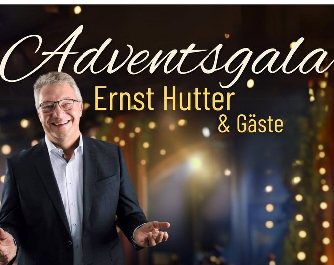 Ein älterer Mann mit kurzen grauen Haaren und Brille in weißem Hemd mit dunklem Jacket breitet einladend die Hände aus. Adventlich wirkender verschwommener Hintergrund mit einzelnen Lichtpunkten. Darüber Schriftzug "Adventsgala Enst Hutter & Gäste".