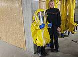 Unsere Berufsfeuerwehrfrau Laura und ein Mädchen im Chemikalienschutzanzug