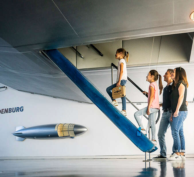 Familie steigt in einen Zeppelin im Museum
