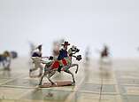 Die deutschen Kämpfer reiten auf Pferden und sind mit Gewehren und Pistolen bewaffnet. 