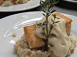 Fisch und Risotto auf einem Teller sehr lecker angerichtet.
