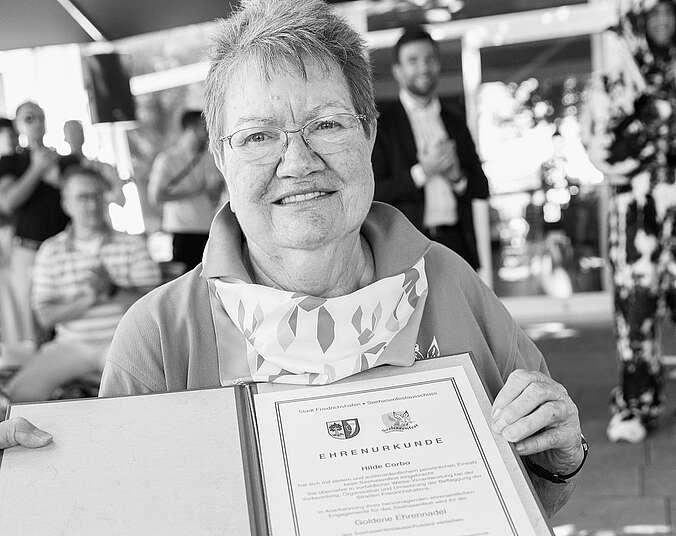 Schwarz-Weiß-Bild von Frau mit Urkunden in den Händen