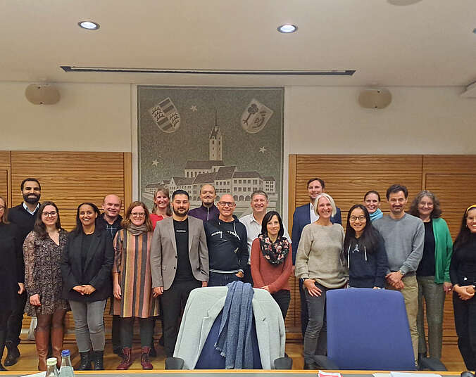 Männer und Frauen stehen vor einem großen Bild