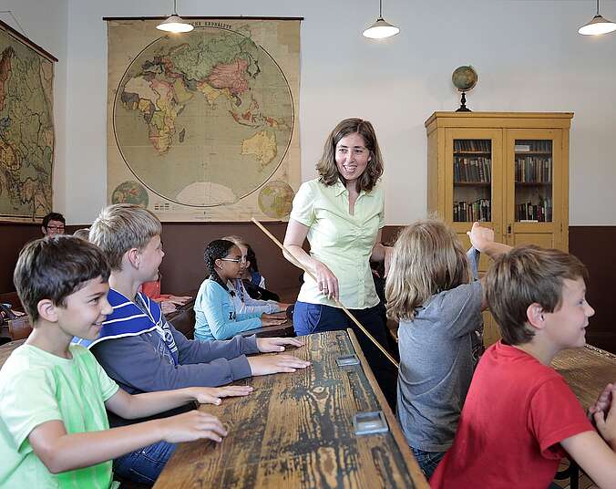 Museumsführerin zeigt historisches Klassenzimmer