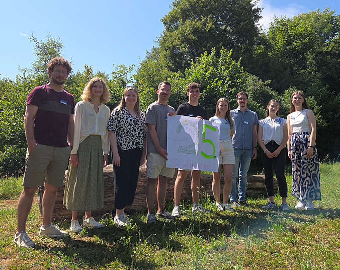 Männer und Frauen stehen in einer Reihe mit einem Schild 25 Jahre FÖJ.