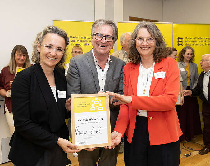 Zwei Frauen und ein Mann präsentieren Urkunde. (Foto: Leif Piechowski)