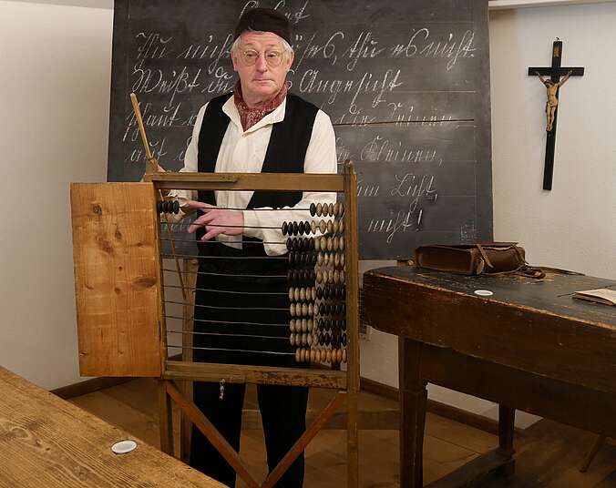 Museumsführer ist als Dorfschulmeister verkleidet