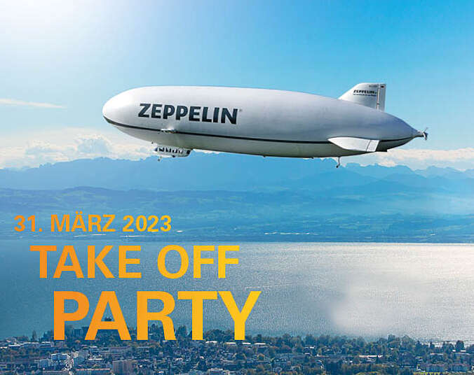Zeppelin fliegt über den Bodensee, im Hintergund Blick auf die Berge
