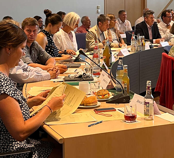 drei Gemeinderäte und eine Gemeinderätin sitzen in Sitzungssaal