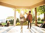 Eine Frau und ein Mann tanzen in der untergehenden Sonne im Pavillon im Uferpark.