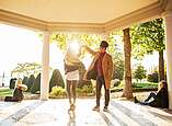 Eine Frau und ein Mann tanzen in der untergehenden Sonne im Pavillon im Uferpark.