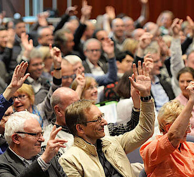 Zahlreiche Menschen stimmen per Handzeichen ab