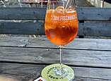 Aperol Spritz steht auch einem Holztisch im Biergarten des Fynn & Henrys.
