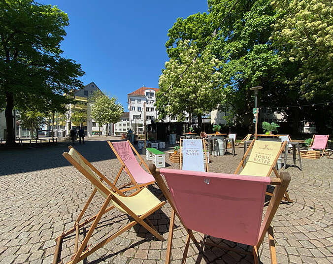 Bunte Liegestühle stehen auf dem Kirchplatz für die Gäste bereit.