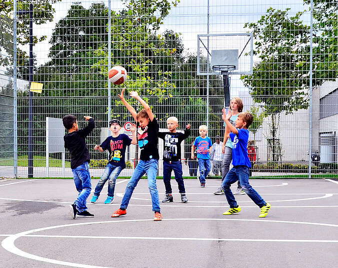 Kinder spielen Basketball