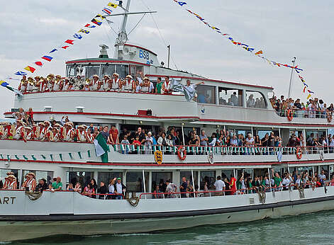 Menschen winken vom Schiff