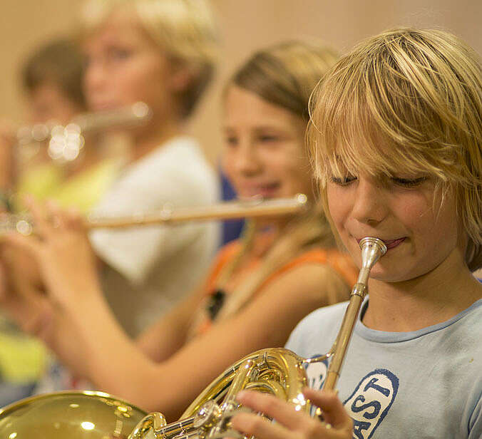 Kinder spielen Horn