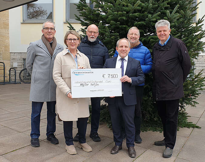 Sechs Personen mit symbolischem Spendenscheck