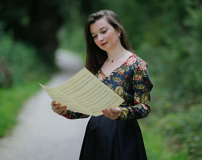 Frau mit Notenblättern in den Händen