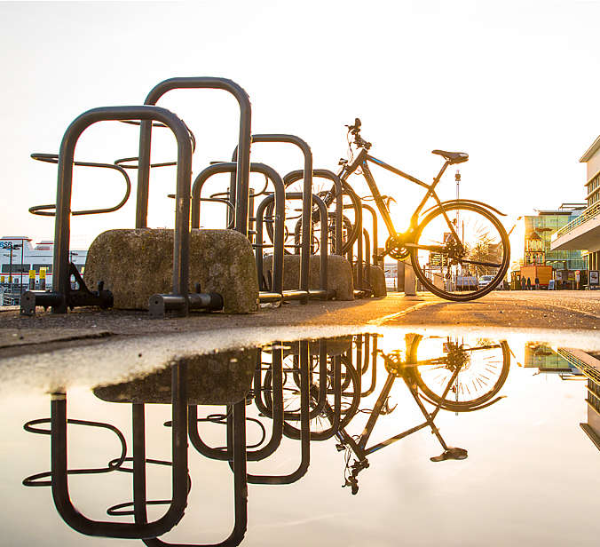 Fahrrad im Fahrradständer Pfütze am Hafen Fahrrad spiegelt sich in Pfütze