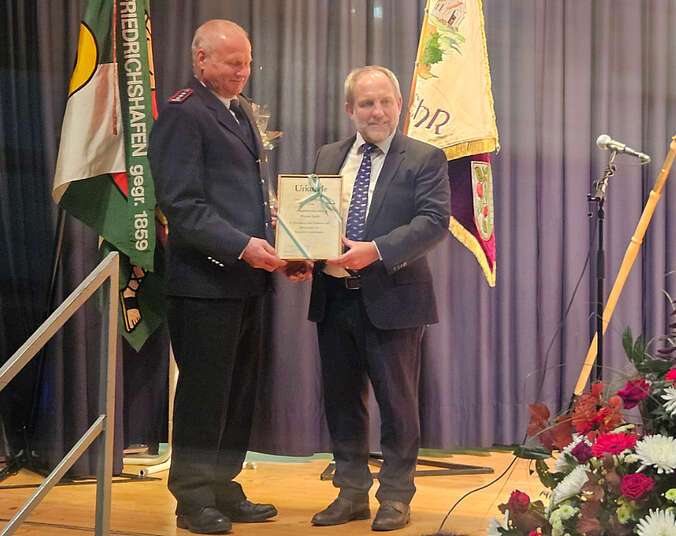 Zwei Männer halten eine Urkunde in den Händen