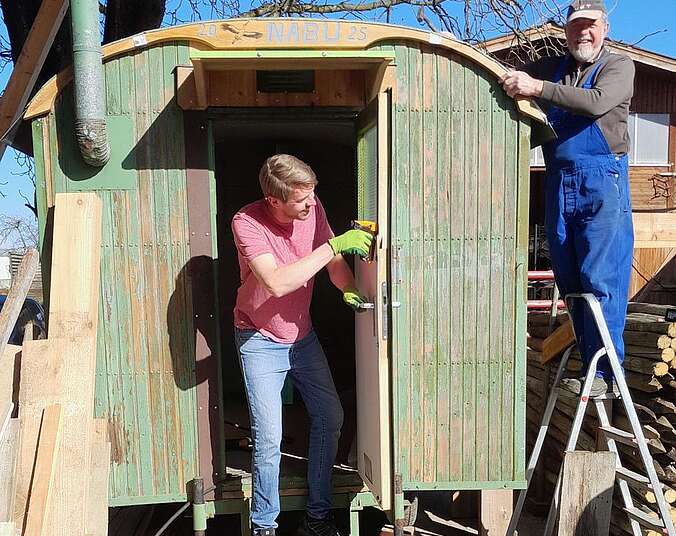 Zwei Männer bauen Bildungs-Bauwagen